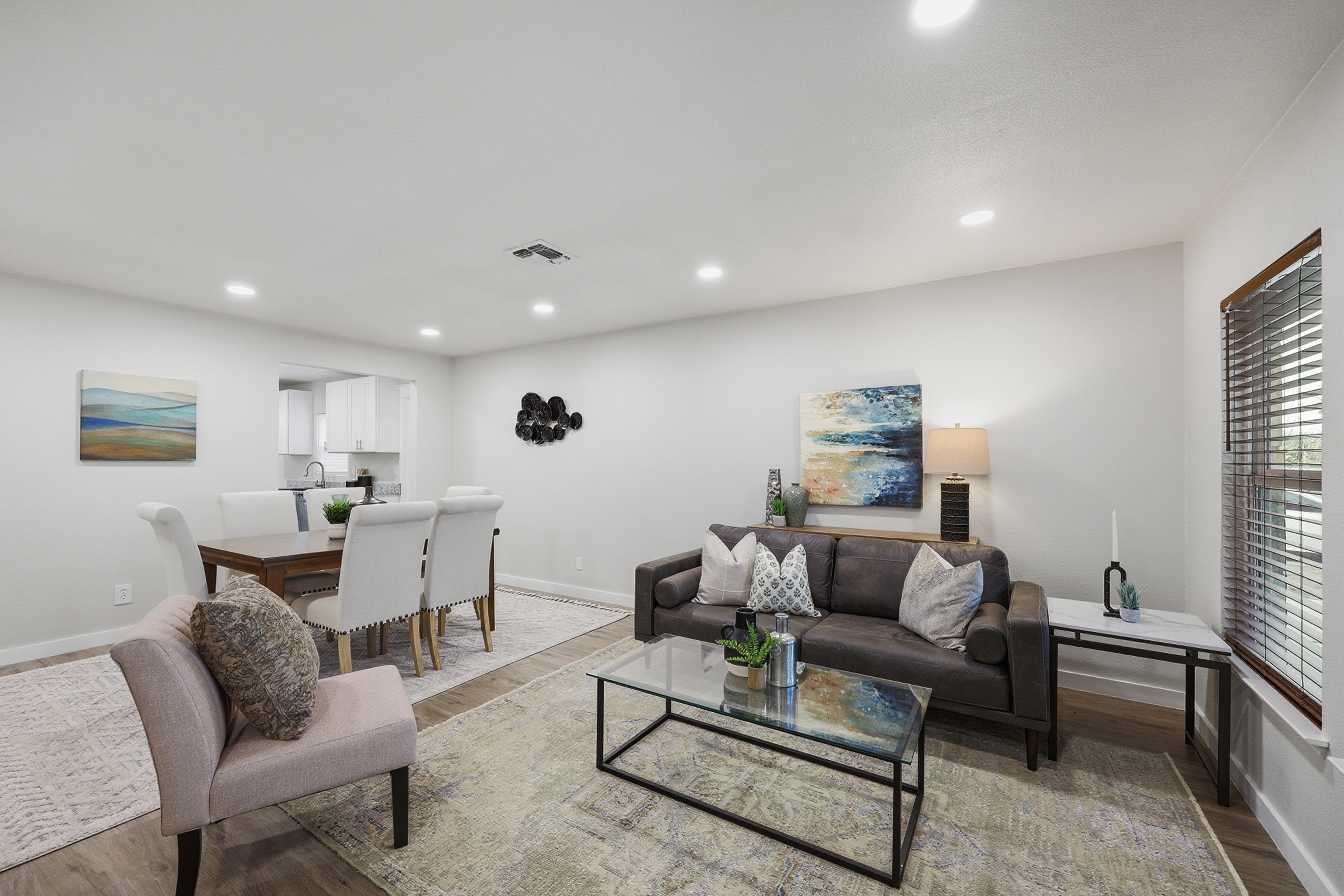 Open living and dining area with modern staging and clean white walls